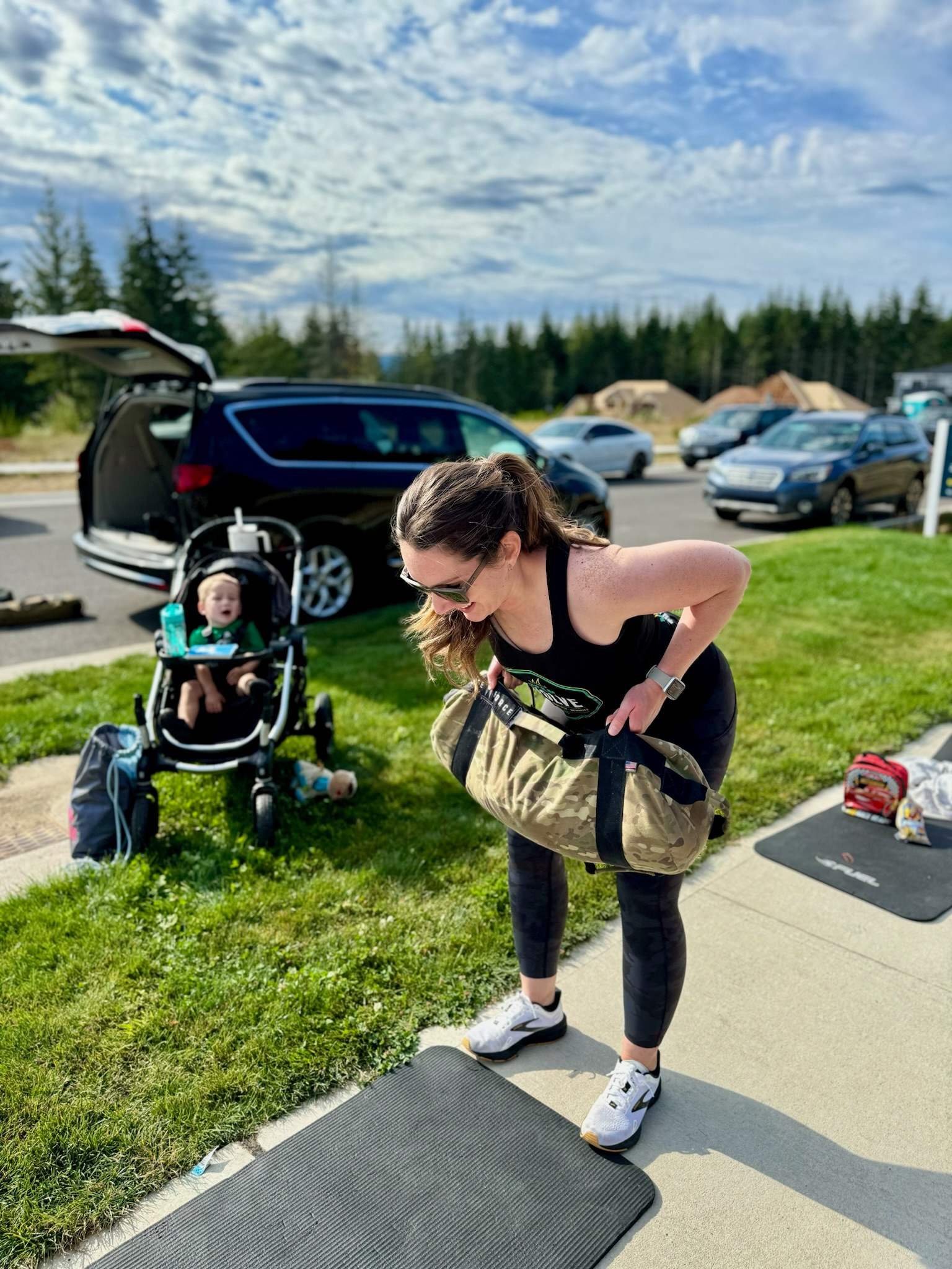 Outdoor workout with sandbag and with kid in stroller 