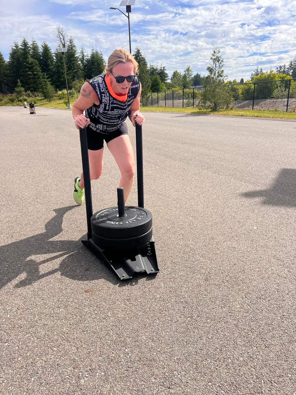 EVOLVE Strong Fitness coaches outside with workout equipment