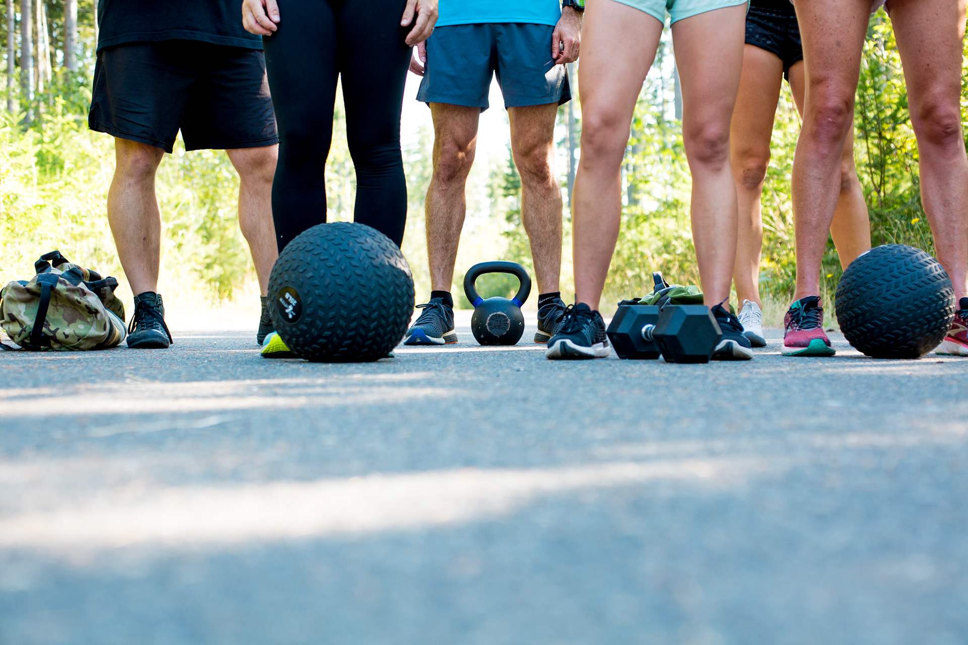 Outdoor fitness class with dumbbells, slam ball, kettlebell